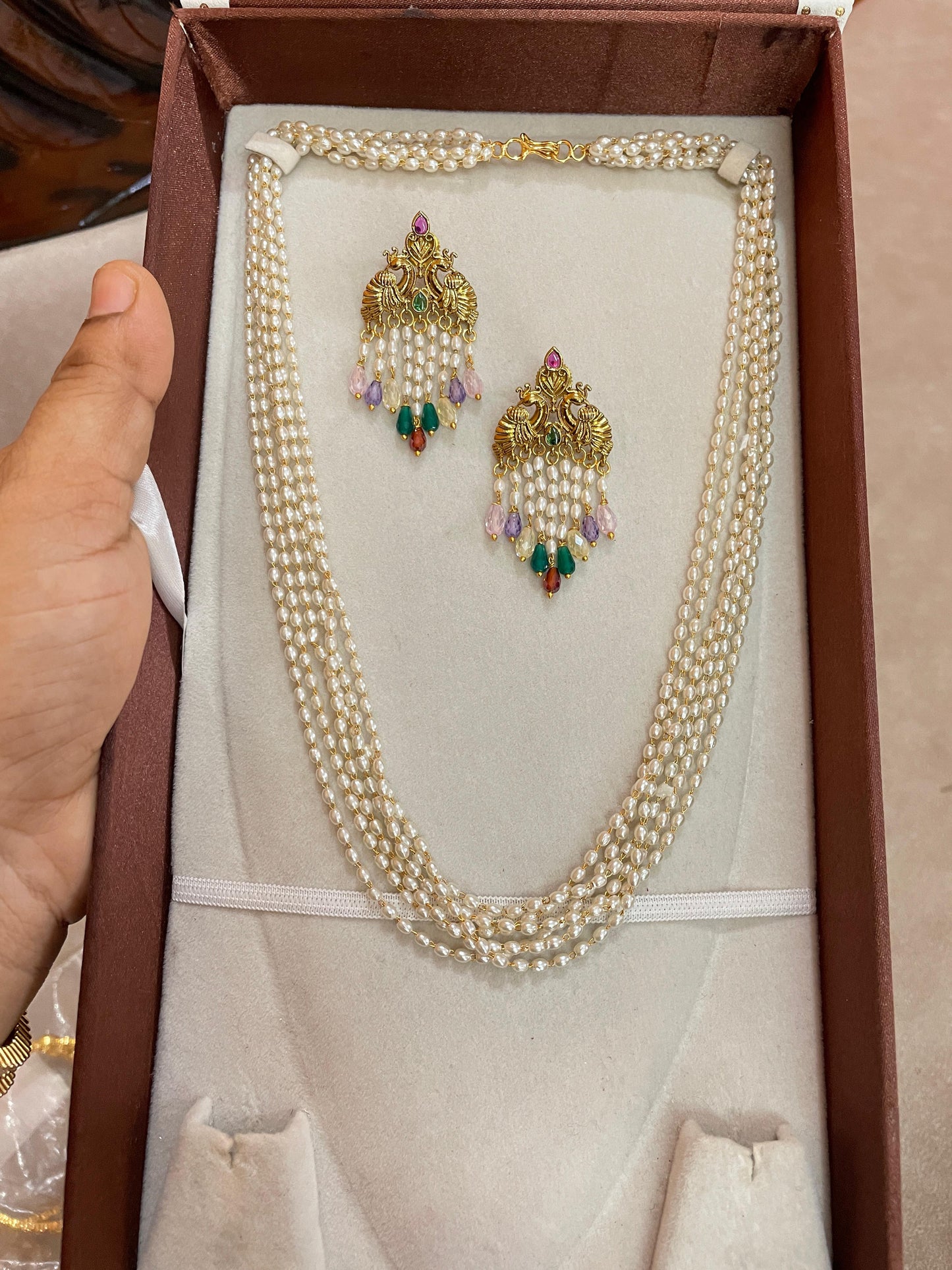 Multi-strand pearl chain with peacock earrings