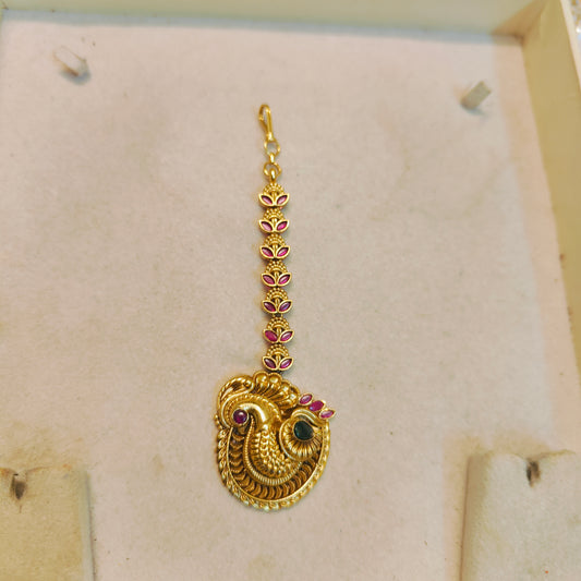 Antique gold peacock maang tikka with ruby accents